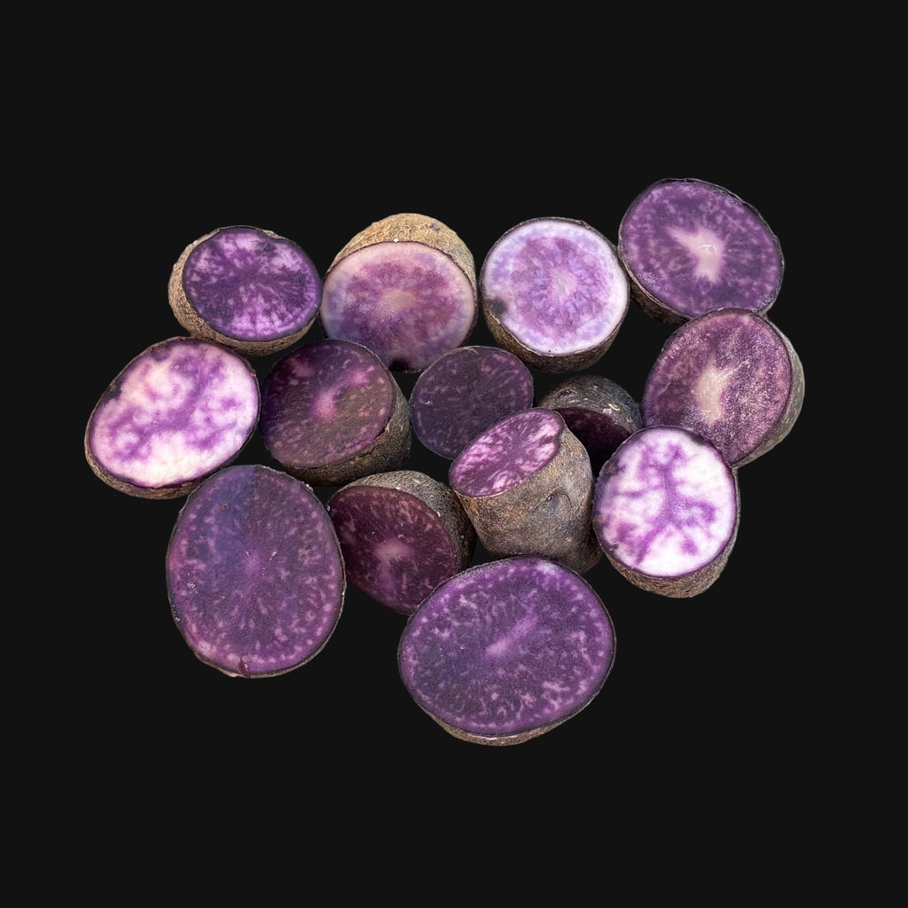 Sliced purple potatoes on a wooden surface